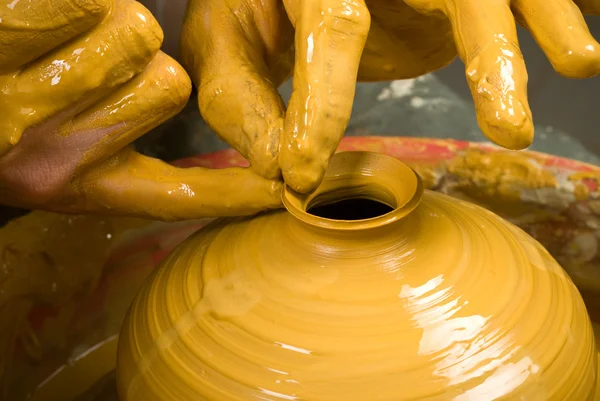 Hands of a potter, creating an earthen jar on the circle — Stock Photo, Image