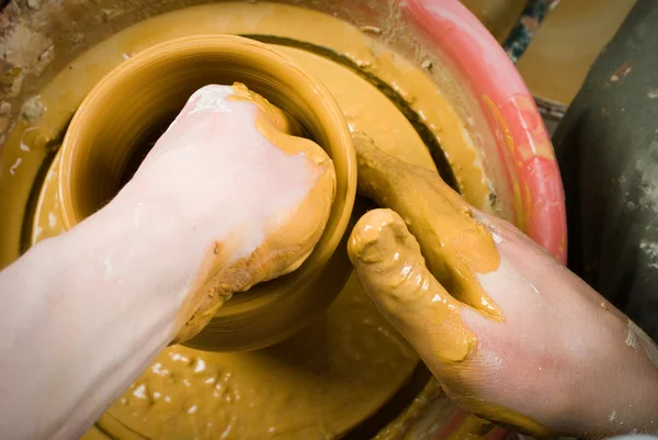 Handen van een pottenbakker, het creëren van een aarden pot op de cirkel — Stockfoto