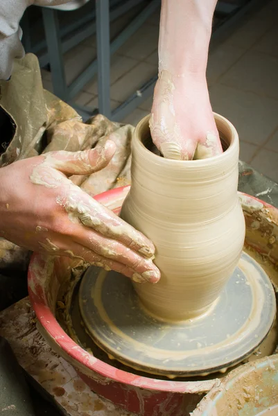 Hands of a potter, creating an earthen jar on the circle — Stock Photo, Image