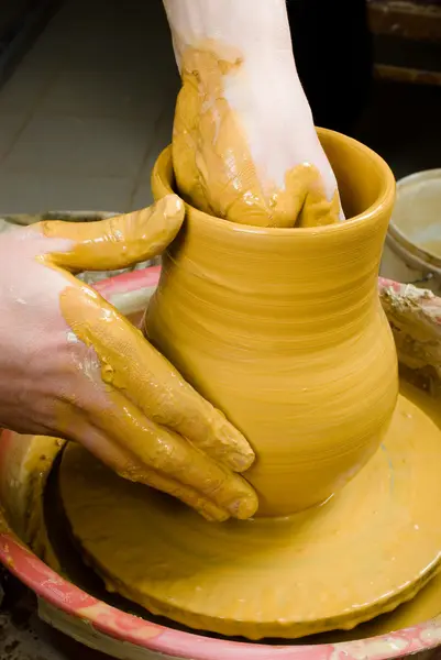 Handen van een pottenbakker, het creëren van een aarden pot op de cirkel — Stockfoto