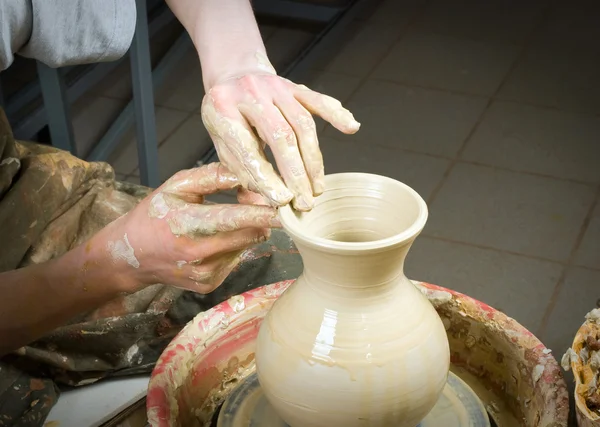 Hands of a potter, creating an earthen jar on the circle — Stock Photo, Image