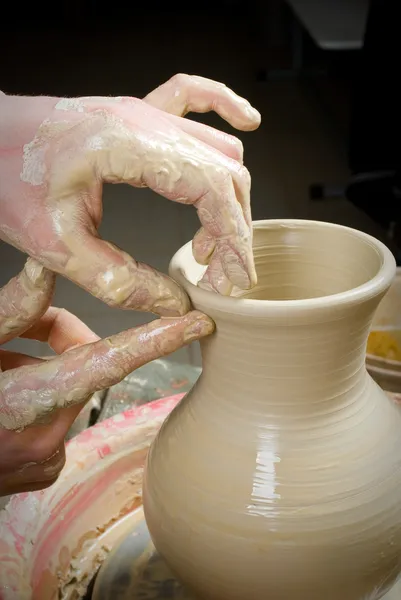 Hands of a potter, creating an earthen jar on the circle — Stock Photo, Image