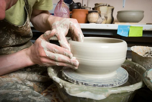 Hands of a potter, creating an earthen jar on the circle — Stock Photo, Image