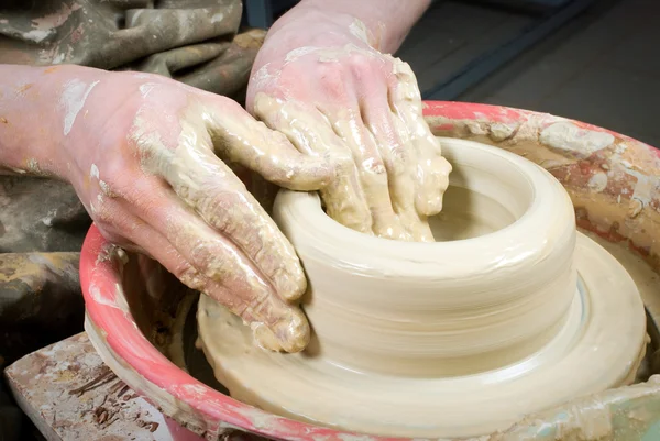 Hands of a potter, creating an earthen jar on the circle — Stock Photo, Image