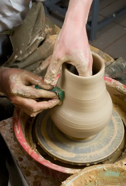 Hands of a potter, creating an earthen jar on the circle — Stock Photo, Image