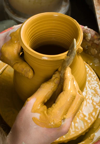 Hands of a potter, creating an earthen jar on the circle — Stock Photo, Image