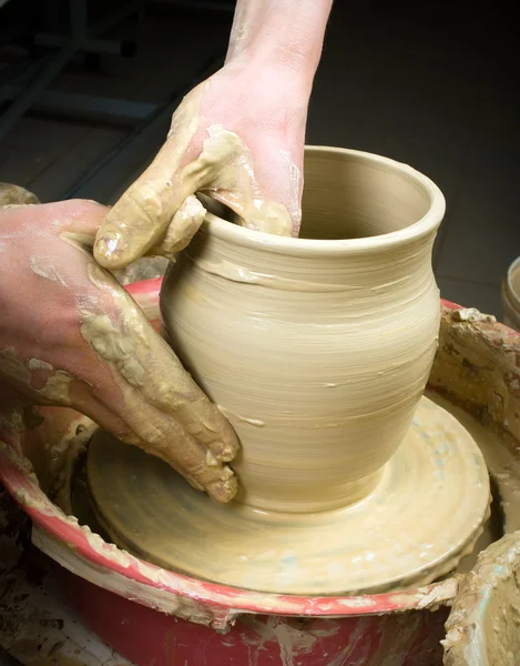 Hands of a potter, creating an earthen jar on the circle — Stock Photo, Image