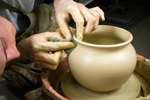 Hands of a potter, creating an earthen jar on the circle — Stock Photo, Image