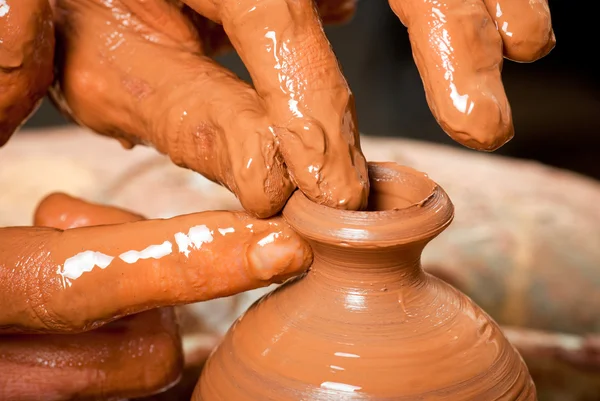 Hands of a potter, creating an earthen jar on the circle — Stock Photo, Image