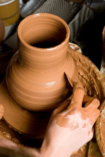 Hands of a potter, creating an earthen jar on the circle — Stock Photo, Image