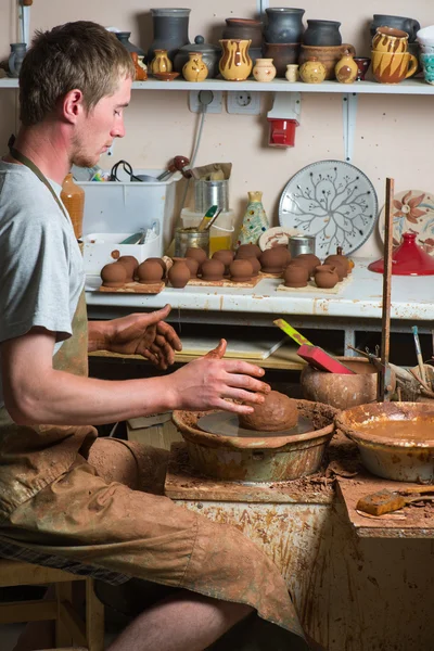 Hands of a potter, creating an earthen jar on the circle — Stock Photo, Image