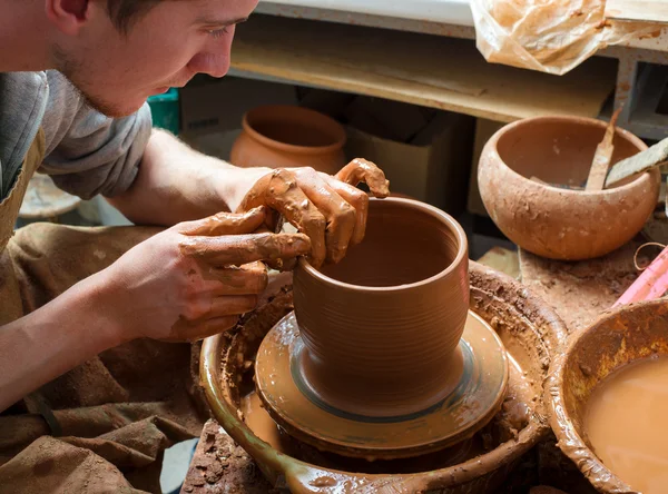 Hands of a potter, creating an earthen jar on the circle — Stock Photo, Image