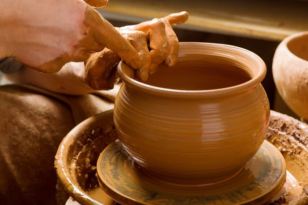 Handen van een pottenbakker, het creëren van een aarden pot op de cirkel — Stockfoto