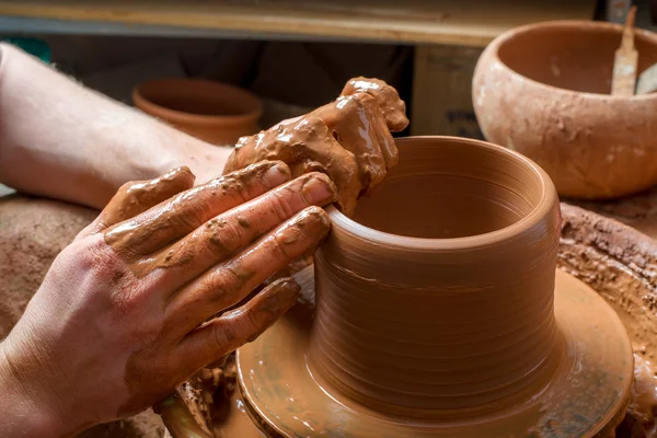 Handen van een pottenbakker, het creëren van een aarden pot op de cirkel — Stockfoto