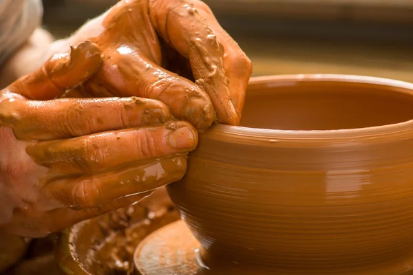 Hands of a potter, creating an earthen jar on the circle — Stock Photo, Image