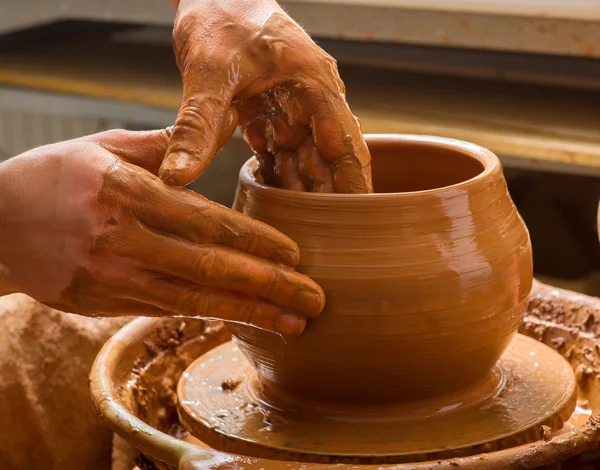 Hands of a potter, creating an earthen jar on the circle — Stock Photo, Image