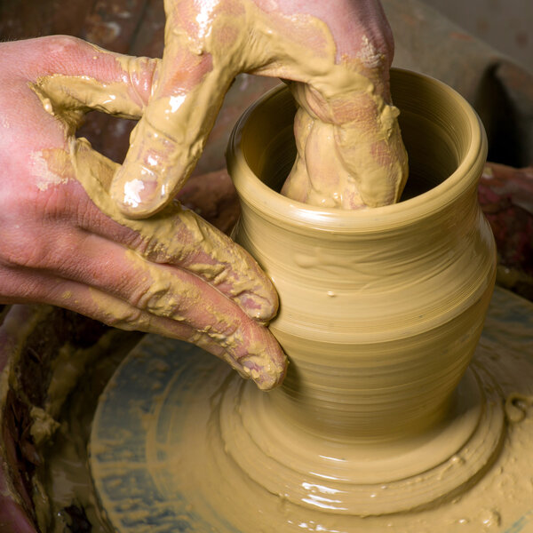 hands of a potter, creating an earthen jar