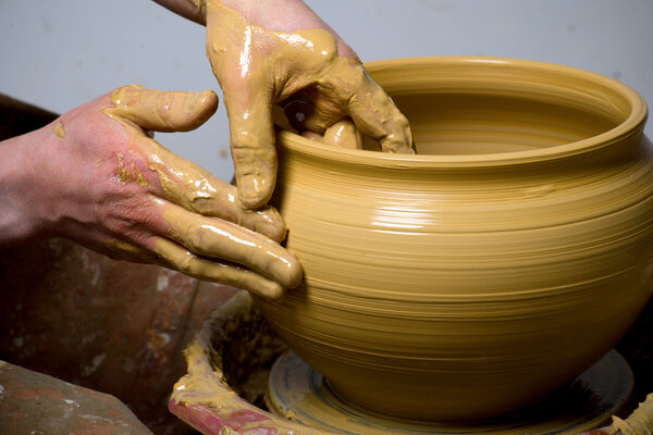 hands of a potter, creating an earthen jar