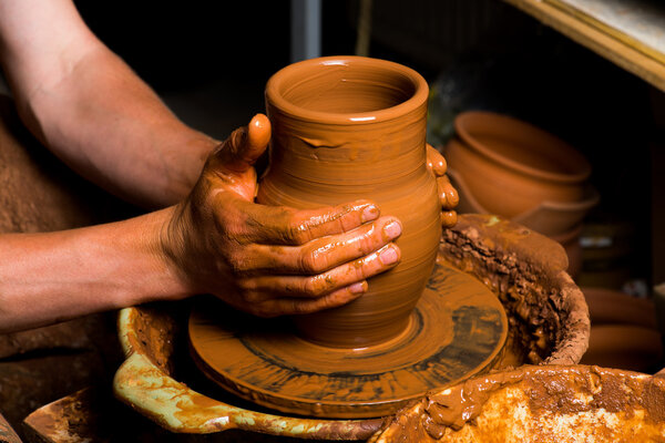 hands of a potter, creating an earthen jar