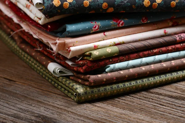 Kupie tkaniny tkaniny na drewnianym stole — Zdjęcie stockowe