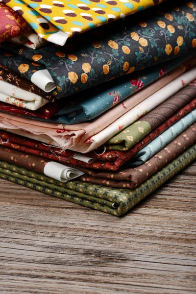 Kupie tkaniny tkaniny na drewnianym stole — Zdjęcie stockowe