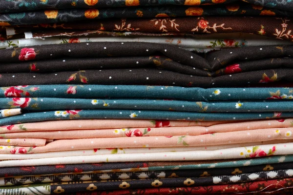 Heap of cloth fabrics on wooden table — Stock Photo, Image