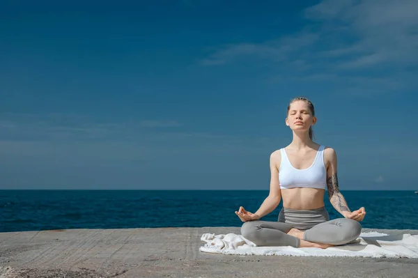 Prática de ioga e meditação na natureza. Mulher praticando perto do mar Negro. Fotos De Bancos De Imagens