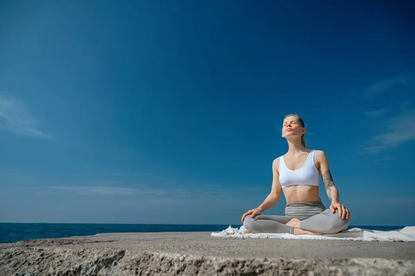 Cvičení jógy a meditace v přírodě. Žena cvičí v blízkosti Černého moře. Stock Obrázky