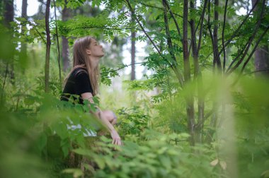 Meditasyon ve doğayla etkileşim pratiği. Yeşil ormandaki kız