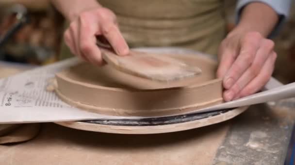 Mistrz ceramiki pracuje w pracowni garncarskiej. Proces tworzenia płytki — Wideo stockowe