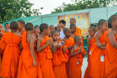 Tayland 'daki Phuket' teki Büyük Buda Tapınağı yakınlarında turuncu elbiseli genç Budistler. 28 Nisan 2019