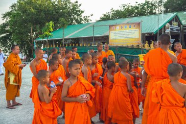 Tayland 'daki Phuket' teki Büyük Buda Tapınağı yakınlarında turuncu elbiseli genç Budistler. 28 Nisan 2019