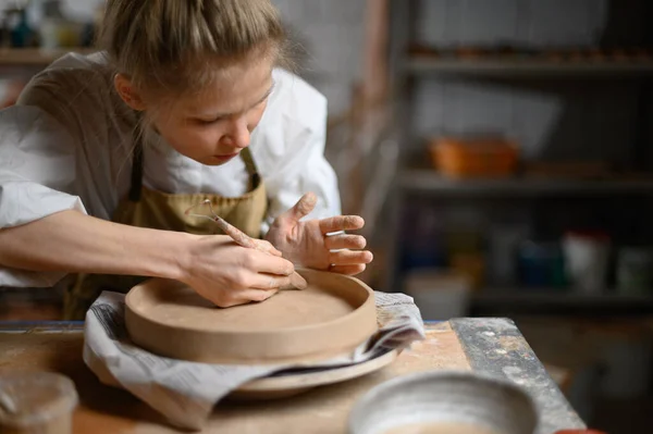 Girl make clay plate in ceramic workshop — Stock Photo, Image