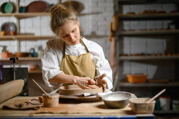 Girl make clay plate in ceramic workshop — Stock Photo, Image
