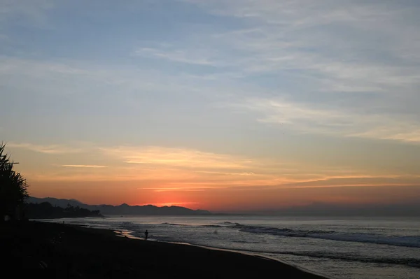 L'alba sul mare. Spiaggia dell'isola al tramonto del mattino. Colorato cielo drammatico sulla spiaggia. Foto Stock