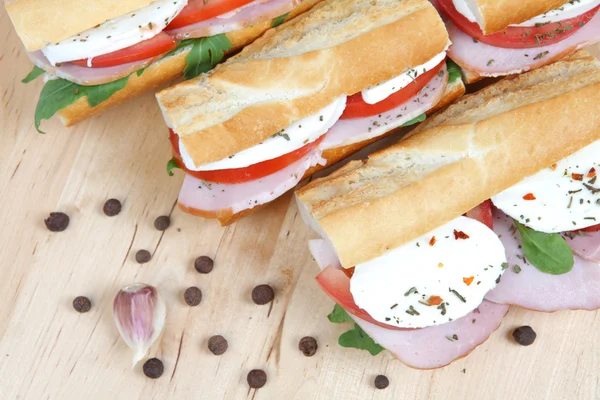 Drei frische Sandwiches mit Tomaten, Schinken und Mozzarella — Stockfoto