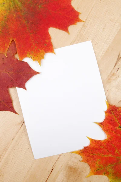 Hojas de otoño con hoja de papel sobre fondo de madera textura —  Fotos de Stock