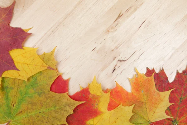 Herfstbladeren op houten achtergrondstructuur — Stockfoto