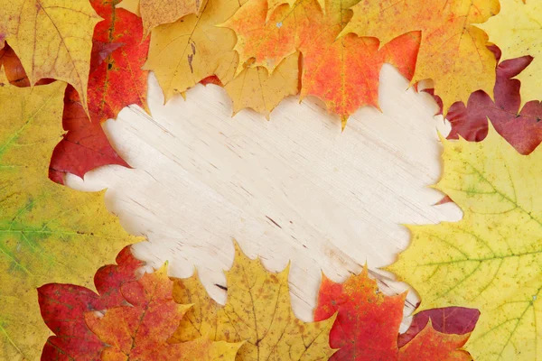 Frame composed of colorful autumn leaves on wooden background te — Stock Photo, Image