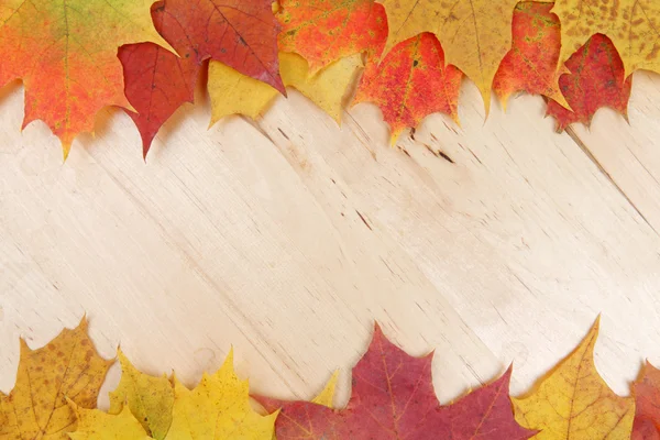 Frame composed of colorful autumn leaves on wooden background te — Stock Photo, Image