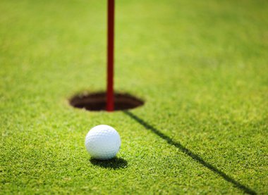 golf ball on lip of cup