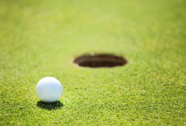 Bola de golfe no lábio do copo — Fotografia de Stock