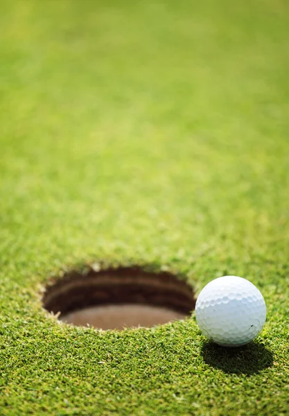 Golf ball op lip van cup — Stockfoto