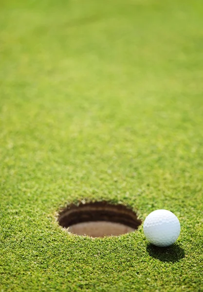 Golf ball op lip van cup — Stockfoto