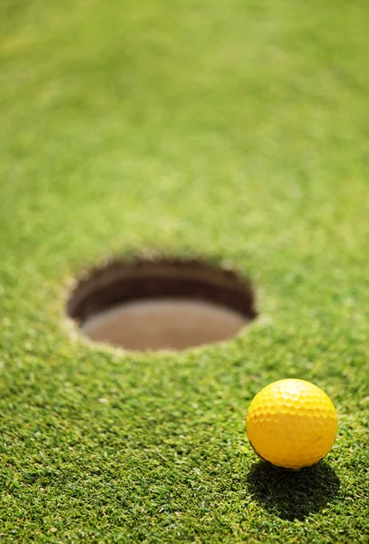 Golf ball op lip van cup — Stockfoto