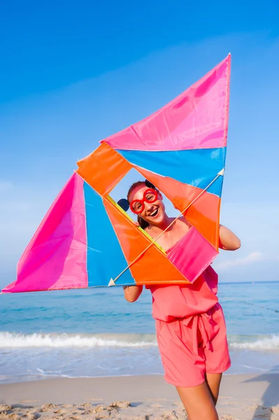 Menina em vestido com óculos de sol na praia do mar com pipa tem jo — Fotografia de Stock