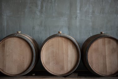 Wine barrels stacked in the cellar of the winery clipart