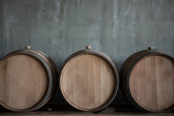 Barris de vinho empilhados na adega — Fotografia de Stock