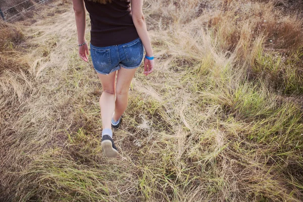 Jong meisje lopen in een veld — Stockfoto