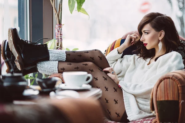 Giovane ragazza che beve caffè in un caffè alla moda — Foto Stock